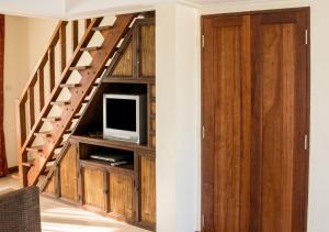 a living room with a staircase with a tv at Cozy apartment in Ko Samui 64 m² with shared pool in Thong Son Beach