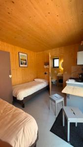 a room with two beds and a desk in it at Lodges Au Cœur des Puys in Nébouzat