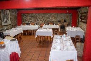 a dining room with white tables and chairs at Cosy Apartment Seia 25 m² Fireplace in Seia +4 photos