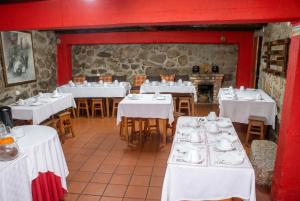 a dining room with white tables and chairs at Cosy apartment in Seia, 25 sqm, welcoming fireplace in Seia