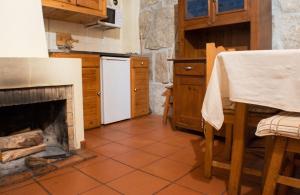 a kitchen with a fireplace and a white refrigerator at Cosy apartment in Seia, 25 sqm, welcoming fireplace in Seia