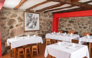 a dining room with white tables and chairs at Cosy apartment in Seia, 25 sqm, welcoming fireplace in Seia