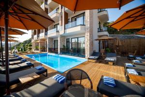 a pool with chairs and umbrellas next to a building at Hotel Potami in Himare