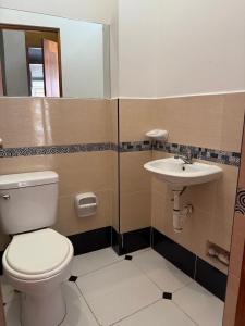 a bathroom with a toilet and a sink at 4-Bedroom Apartment in Quillabamba