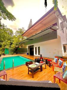 a backyard with a pool and a table and chairs at Nature View Friends Villa - The Dream Stays ll Infinity Big pool ll 3Rooms ll Wi-Fi in Lonavala