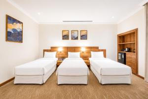 four beds in a room with white walls at فندق تيلا TeeLA HoTeL in Medina