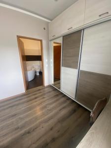 a room with wooden floors and sliding glass doors at Tündér Pension in Mogyoród