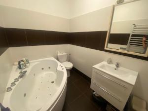 a bathroom with a tub and a toilet and a sink at Tündér Pension in Mogyoród