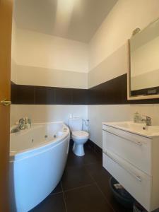 a bathroom with a tub and a toilet and a sink at Tündér Pension in Mogyoród +65 photos