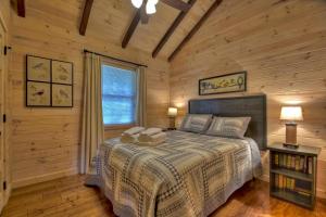 a bedroom with a bed in a log cabin at Blueberry Hill Fire Pit MTN Views Grill in McCaysville