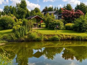 a house reflected in the water of a lake at Leśny Staw Stodoła in Gilwa