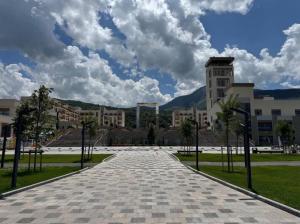a brick walkway in front of a large building at Чарвак Дарвозаси in Chorwoq