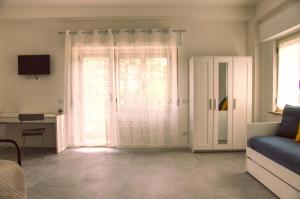 a room with a bed and a window with curtains at Casa Alice in Numana