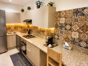 a kitchen with a refrigerator and a counter top at Pool View Apartment Gated Residence in Sidi Rahal