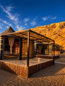 a building in the desert with a mountain in the background at Skylight Wadi Rum Camp in Disah