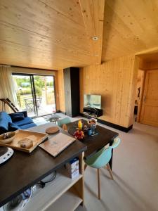 a kitchen and living room with a table and chairs at Lodges Au Cœur des Puys in Nébouzat