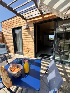 a blue table with a basket of fruit on a patio at Lodges Au Cœur des Puys in Nébouzat