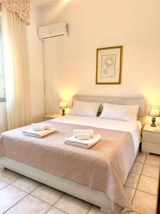 a bedroom with a large bed with two towels on it at S'Olivare Posada - Apartment in Posada