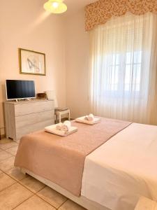 a bedroom with a bed with two towels on it at S'Olivare Posada - Apartment in Posada
