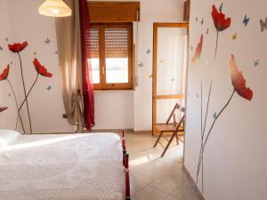 a bedroom with a bed and flowers on the wall at Charming Apartment in Velina, 90 m², Mountain View in Castelnuovo Cilento