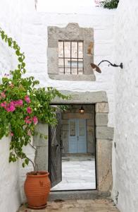 ein Eingang zu einem Gebäude mit einer Tür und Blumen in der Unterkunft Family House with Sea View in Patmos + Terrace in Patmos