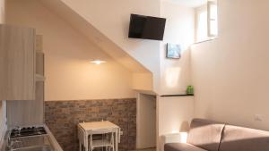 a living room with a couch and a tv on the wall at Charming studio with air conditioning in Gragnano - 35 sqm in Gragnano