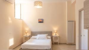 a bedroom with a white bed and two night stands at Charming studio with air conditioning in Gragnano - 35 sqm in Gragnano