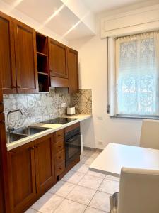 a kitchen with wooden cabinets and a sink at S'Olivare Posada - Apartment in Posada