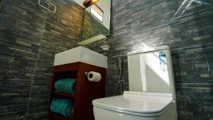 a bathroom with a toilet and a mirror and towels at Golden Sky Hotel & Wellness in Kandy +30 photos