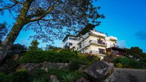a white house on top of a hill at Golden Sky Hotel & Wellness in Kandy