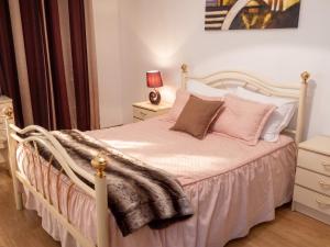 a bedroom with a white bed with pink pillows at Charming Apartment in Alvoco da Serra with Mountain View in Alvoco da Serra
