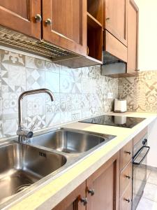 a kitchen with a stainless steel sink and wooden cabinets at S'Olivare Posada - Apartment in Posada +9 photos