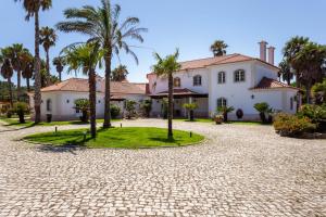 a house with palm trees in front of a driveway at Casa do Marco in Sintra