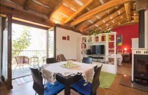 a dining room with a table and chairs and a fireplace at Stonehouse LOFT MARTA in Vergato