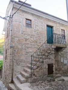 a stone building with stairs and a green door at Charming Apartment in Alvoco da Serra - Mountain View - 50 sqm in Alvoco da Serra