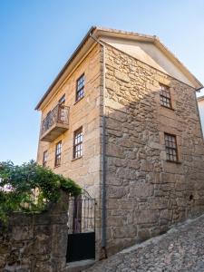 an old stone building with windows and a balcony at Charming Apartment in Alvoco da Serra - Mountain View - 50 sqm in Alvoco da Serra +4 photos