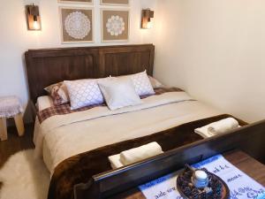 a bedroom with a large bed with a wooden headboard at Elegant villa with jacuzzi near Možđenec in Možđenec