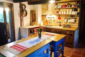 a kitchen with a wooden table and blue chairs at Elegant villa with jacuzzi near Možđenec in Možđenec