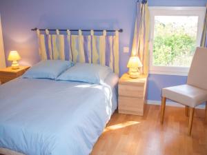 a bedroom with a bed and a chair and a window at Maison charmante à Saint-Vincent-la-Châtre avec piscine partagée in Saint-Vincent-la-Châtre