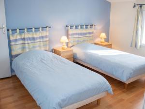 two beds in a room with two lamps at Maison charmante à Saint-Vincent-la-Châtre avec piscine partagée in Saint-Vincent-la-Châtre +2 photos