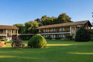 a large building in a yard with a bush at Hotel Casa De Campo in Santa Cruz
