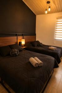 two beds in a room with towels on them at Cabaña de lujo BlackMoon in Mazamitla