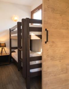 a bunk bed room with two bunk beds and a door at Appartement charmant à Briançon de 40 m² avec balcon in Briançon
