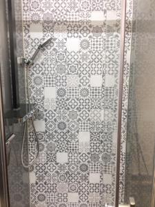 a bathroom with a shower with a tiled wall at Appartement charmant à Briançon de 40 m² avec balcon in Briançon
