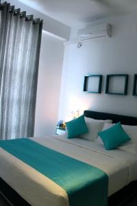a bedroom with a large bed with green and white pillows at Mount Princess in Mount Lavinia