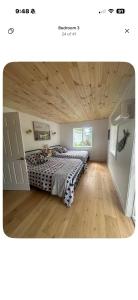 a bedroom with a bed and a wooden ceiling at Cozy cottage by the beach in Pointe-du-Chêne