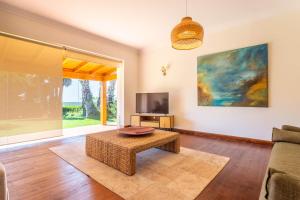 a living room with a couch and a table and a tv at Casa do Marco in Sintra