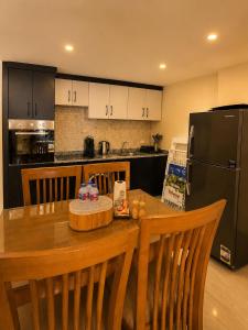 a kitchen with a wooden table and a black refrigerator at 1 BDR Pool Front Cozy Apartment in Port Ghalib