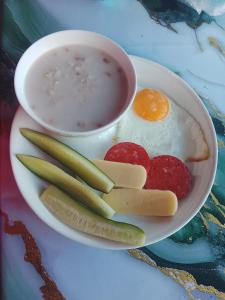 a plate of food with eggs and vegetables and a cup of soup at Madriel Eko Retreat in Bokonbayevo