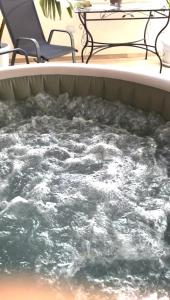 a hot tub filled with water next to two chairs at Suite SWEET DREAMS Dan champs in San Vito lo Capo